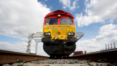 The image shows a freight train departing from London on the way to Zhejiang