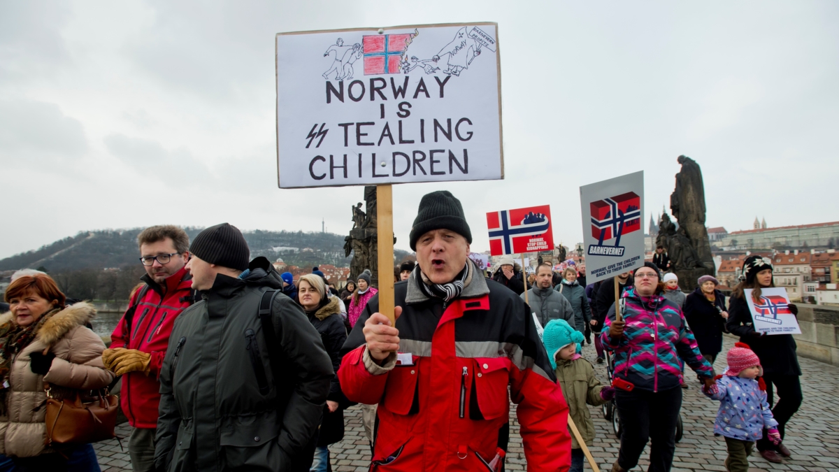 Bildet viser en protest mot norsk barnevern i Praha i 2016.I forgrunnen mann i halvfigur som roper og bærer plakat med påskriften "Norway is stealing children"