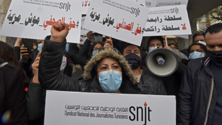 The image shows journalists demonstrating in Tunisia.